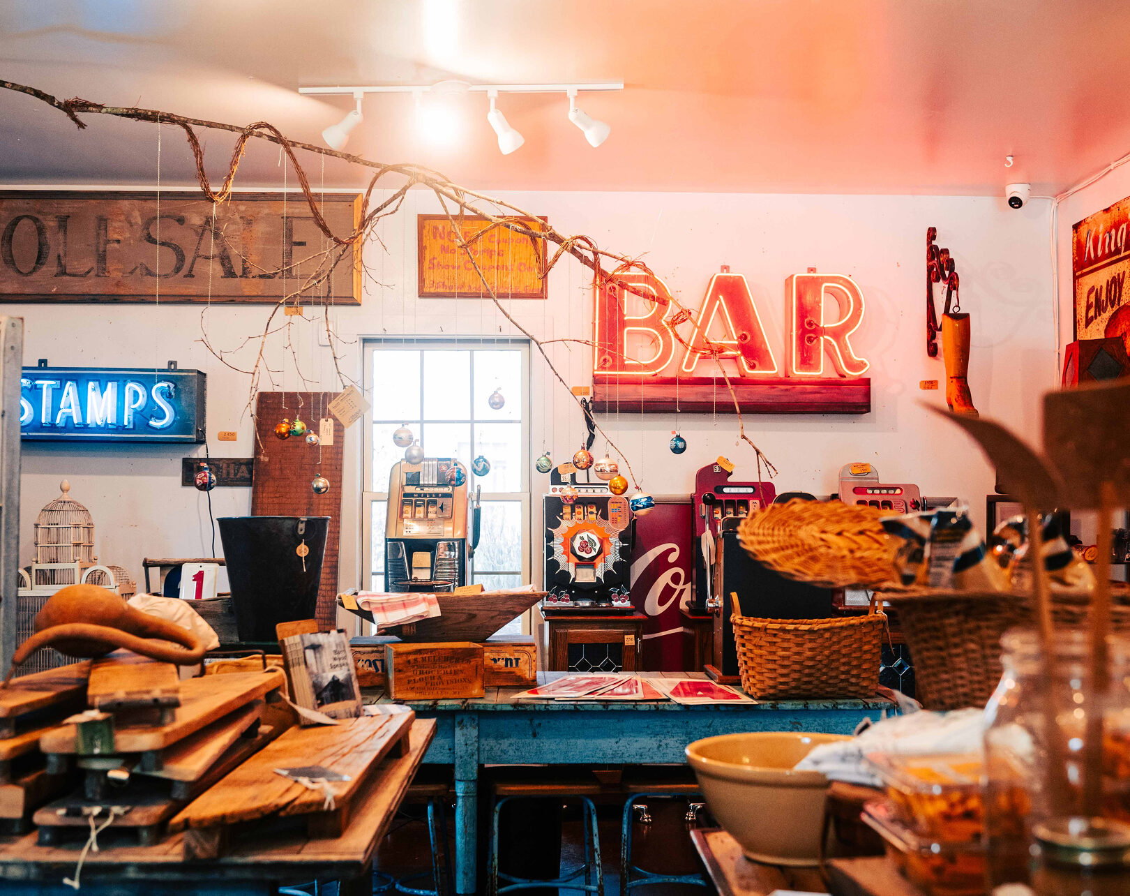 Eclectic vintage shop interior featuring neon BAR sign and antique collectibles